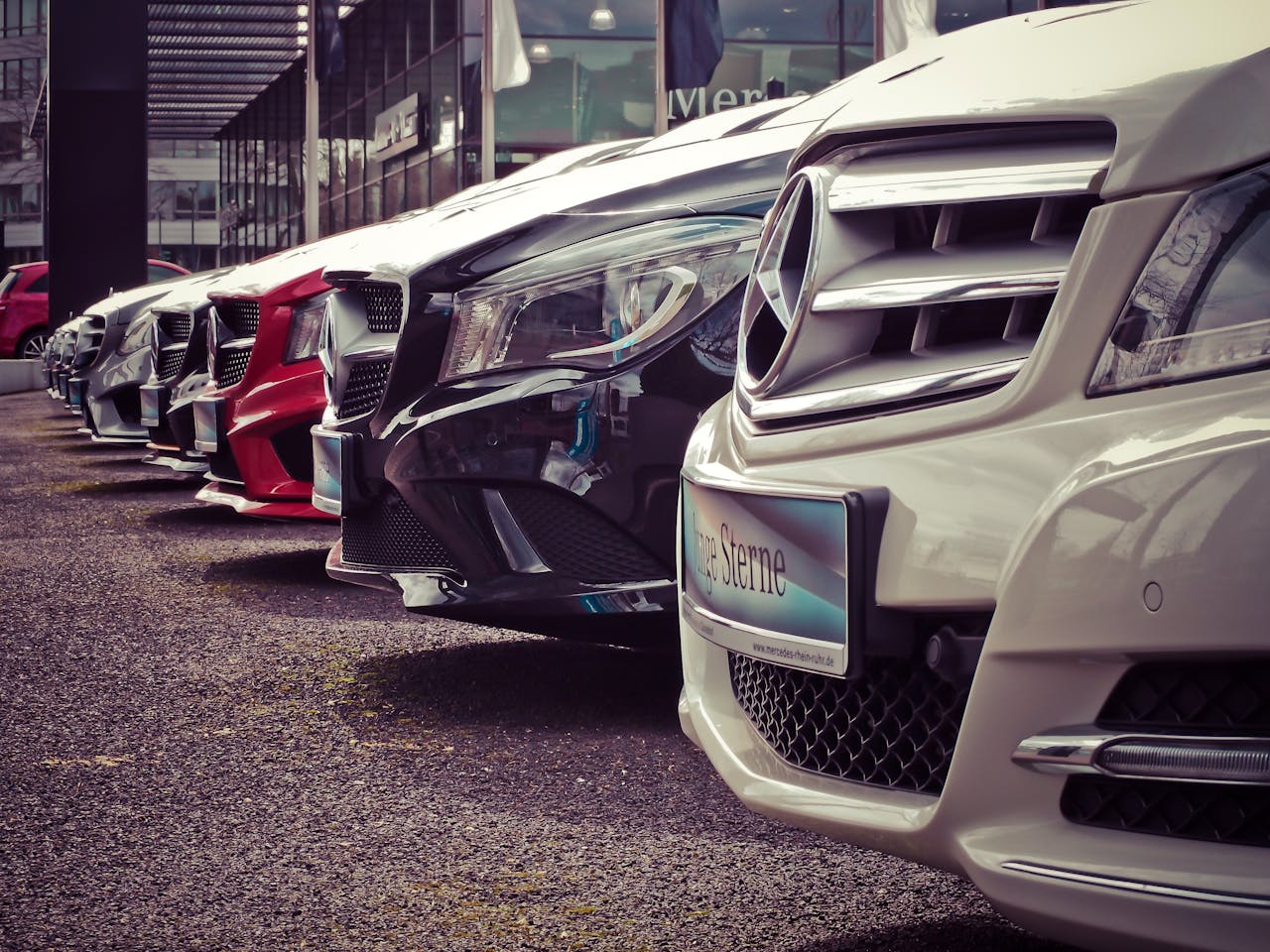 Home Luxury cars lined up at an outdoor dealership, showcasing sleek designs.